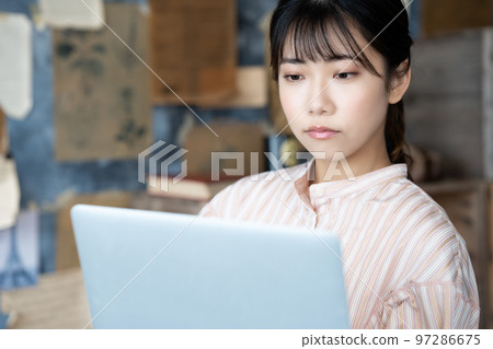 一個女人在別緻的房間裡使用筆記本電腦 97286675