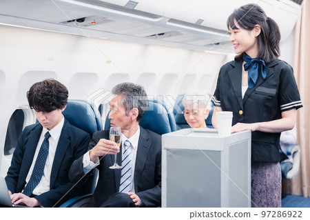 Cabin crew serving drinks onboard Cabin crew serving drinks onboard 97286922