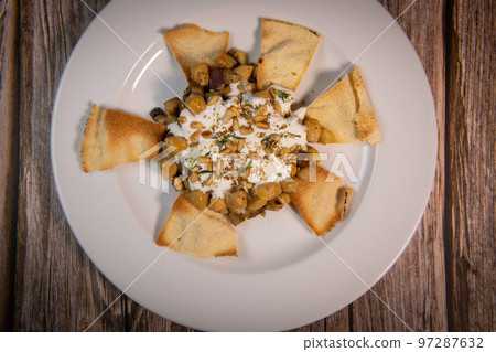 Oriental recipe aubergine and chickpea fatteh, pita, Greek yogurt, roasted pine nuts, zaatar Oriental recipe aubergine and chickpea fatteh, pita, Greek yogurt, roasted pine nuts, zaatar 97287632