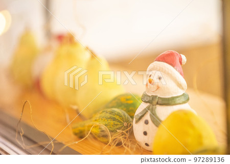A snowman doll placed by the window 97289136
