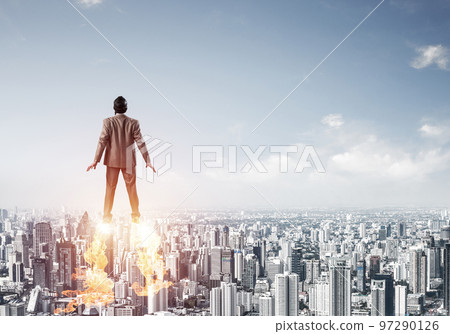 Businessman in suit and aviator hat flying in sky Businessman in suit and aviator hat flying in sky 97290126