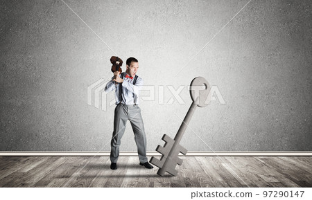 Breaking through access concept with man in room crashing concrete key 97290147