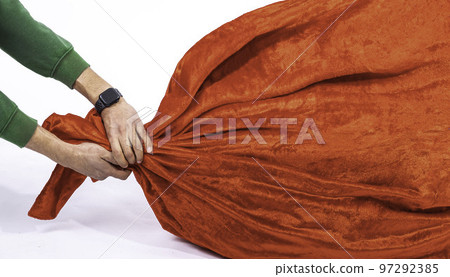 mans hands in a green hoodie pulls red bag ,delivers Christmas gifts on a white background mans hands in a green hoodie pulls red bag ,delivers Christmas gifts on a white background 97292385