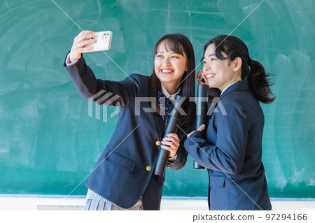 拿著畢業證在教室裡拍紀念照的高中生 拿著畢業證在教室裡拍紀念照的高中生 97294166
