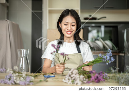 Weekend with her hobbies, Asian woman arranges a bouquet of flowers to decorate her home and beautify, Artificial flower arrangement, living room decoration ideas, Flowers bunch, Arts and crafts 97295263