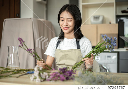 Weekend with her hobbies, Asian woman arranges a bouquet of flowers to decorate her home and beautify, Artificial flower arrangement, living room decoration ideas, Flowers bunch, Arts and crafts Weekend with her hobbies, Asian woman arranges a bouquet of flowers to decorate her home and beautify, Artificial flower arrangement, living room decoration ideas, Flowers bunch, Arts and crafts 97295767