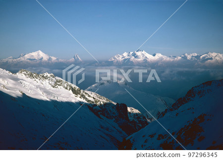 Panorama of snowy mountains and high alpine peaks in wintery Bernese Oberland in Switzerland Panorama of snowy mountains and high alpine peaks in wintery Bernese Oberland in Switzerland 97296345