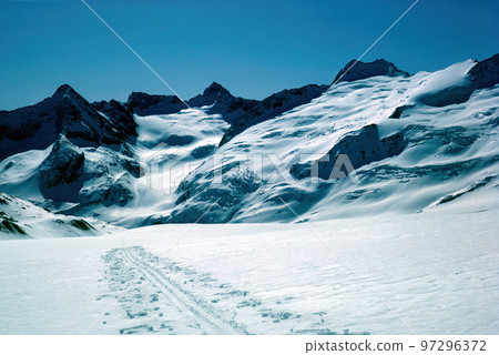 Panorama of snowy mountains and high alpine peaks in wintery Bernese Oberland in Switzerland Panorama of snowy mountains and high alpine peaks in wintery Bernese Oberland in Switzerland 97296372