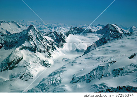Panorama of snowy mountains and high alpine peaks in wintery Bernese Oberland in Switzerland Panorama of snowy mountains and high alpine peaks in wintery Bernese Oberland in Switzerland 97296374