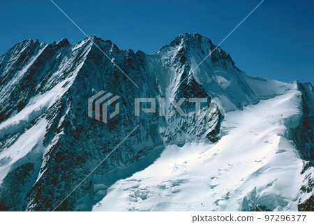 Panorama of snowy mountains and high alpine peaks in wintery Bernese Oberland in Switzerland 97296377