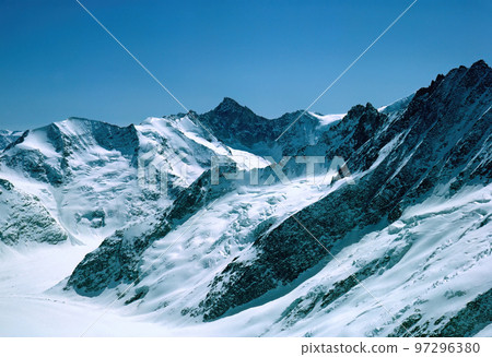 Panorama of snowy mountains and high alpine peaks in wintery Bernese Oberland in Switzerland Panorama of snowy mountains and high alpine peaks in wintery Bernese Oberland in Switzerland 97296380