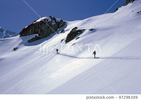 High alpine skiers on the way to the summit in winter Bernese Oberland in switzerland High alpine skiers on the way to the summit in winter Bernese Oberland in switzerland 97296389