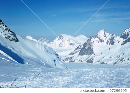 Panorama of snowy mountains and high alpine peaks in wintery Bernese Oberland in Switzerland 97296395