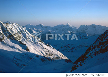 Panorama of snowy mountains and high alpine peaks in wintery Bernese Oberland in Switzerland 97296406