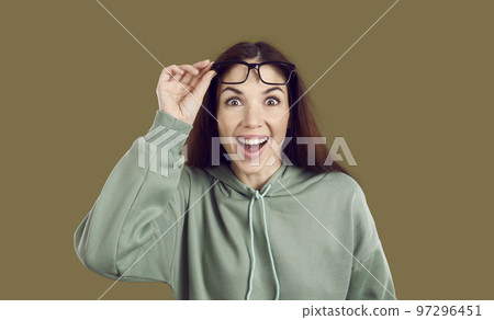 Overjoyed Caucasian woman raises glasses from eyes experiencing WOW emotions from offer for shopping Overjoyed Caucasian woman raises glasses from eyes experiencing WOW emotions from offer for shopping 97296451