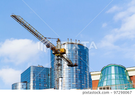 Construction in metropolis. Construction crane on background of business center in city center. Construction in metropolis. Construction crane on background of business center in city center. 97298067