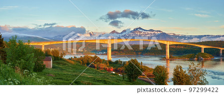 Landscape view of Saltstraumen Bridge in Nordland, Norway in winter. Scenery of transport infrastructure over a river or stream with a snow capped mountain background in travels abroad and overseas Landscape view of Saltstraumen Bridge in Nordland, Norway in winter. Scenery of transport infrastructure over a river or stream with a snow capped mountain background in travels abroad and overseas 97299422