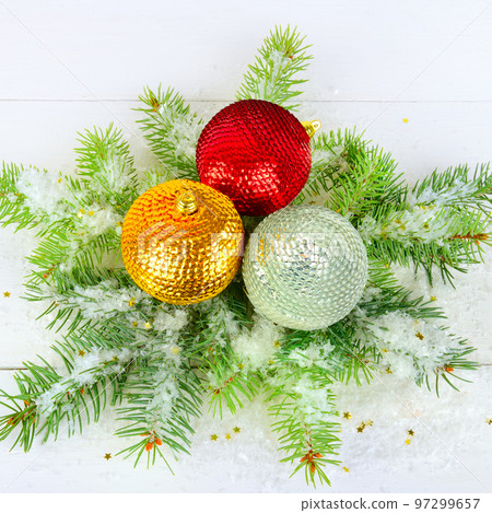 A sprig of fir, Christmas multicolored balls and snow on a white wooden. A sprig of fir, Christmas multicolored balls and snow on a white wooden. 97299657
