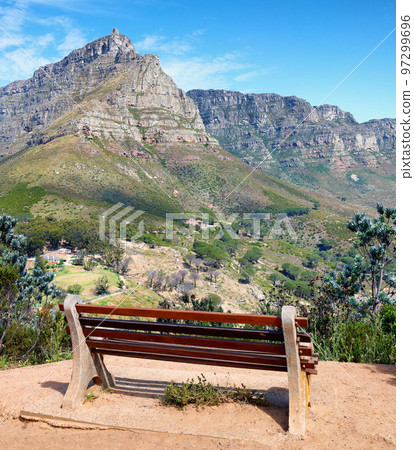 Seating bench in a relaxing mountain range in a botanical garden. Table Mountain National park in Cape Town, South Africa with blue sky and local seating to enjoy calm and zen view of mother nature Seating bench in a relaxing mountain range in a botanical garden. Table Mountain National park in Cape Town, South Africa with blue sky and local seating to enjoy calm and zen view of mother nature 97299696