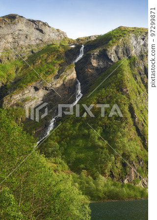 Mountain spring water flowing through a jungle thicket on an island, nature in its purest form. Beautiful landscape of clean river water coming down a rocky hill on a summer day outdoors in nature. 97299871