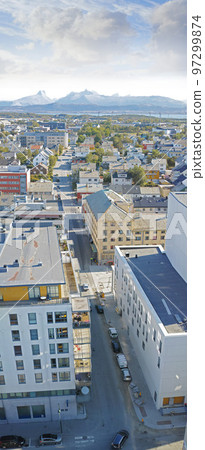 Above view of urban city streets in popular overseas travel destination in Bodo, Norway. Busy downtown centre and urban infrastructure of building architecture with scenic mountains in the background 97299874