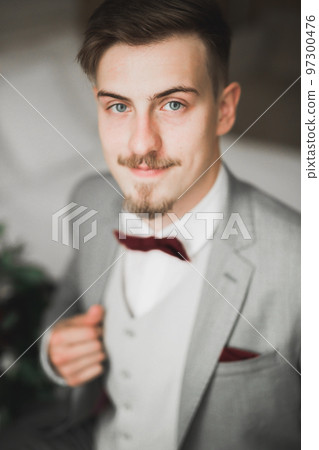 Grooms morning preparation. Handsome man getting dressed and preparing for the wedding Grooms morning preparation. Handsome man getting dressed and preparing for the wedding 97300476