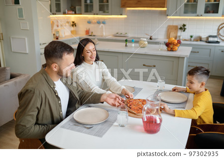 Happy mother, father and son eating italian homemade pizza 97302935