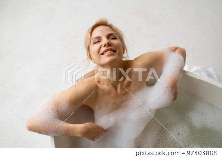 Joyful woman enjoying rest and relax in bath during home spa on weekend Joyful woman enjoying rest and relax in bath during home spa on weekend 97303088