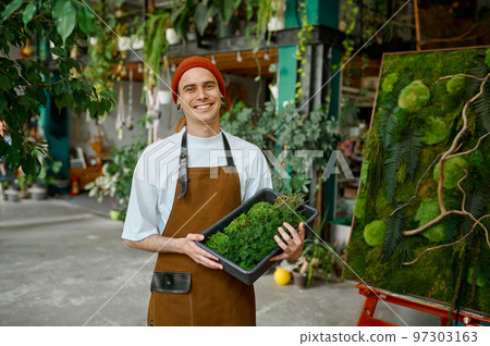 Portrait of young florist standing at creative floral composition 97303163