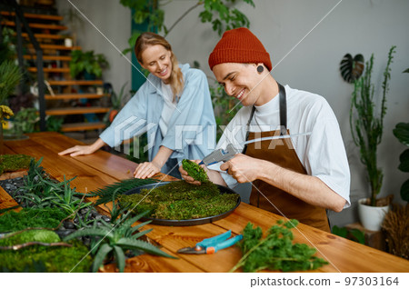 Woman florist teaching young hipster man decorator at art craft studio 97303164