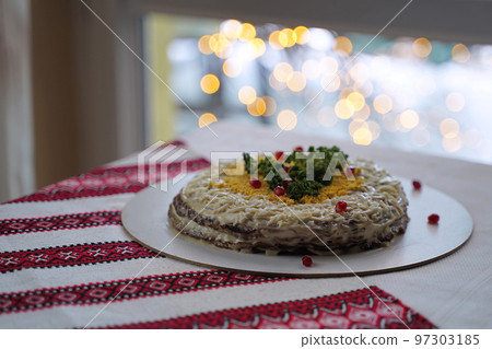 Homemade layered liver cake. Traditional Ukrainian food on the table with embroidered tablecloth. Homemade layered liver cake. Traditional Ukrainian food on the table with embroidered tablecloth. 97303185