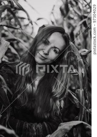 Long haired woman stands enjoying corn plantations Long haired woman stands enjoying corn plantations 97304029