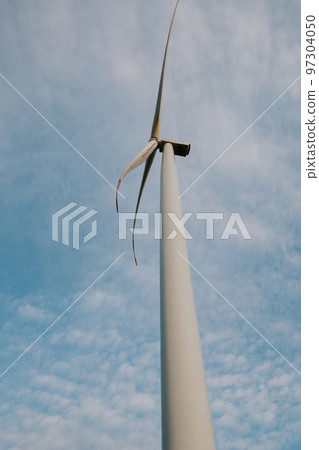 Windmill generates clean energy with propeller against sky Windmill generates clean energy with propeller against sky 97304050
