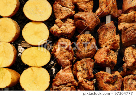 Delicious piece of meat fried over the fire at a picnic. Delicious piece of meat fried over the fire at a picnic. 97304777