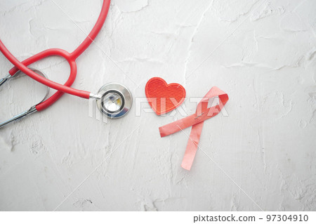 Red ribbon HIV, and stethoscope on pink background. Red ribbon HIV, and stethoscope on pink background. 97304910
