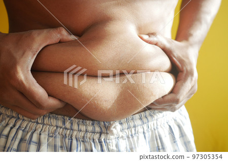 fat man with a big belly against yellow background  97305354