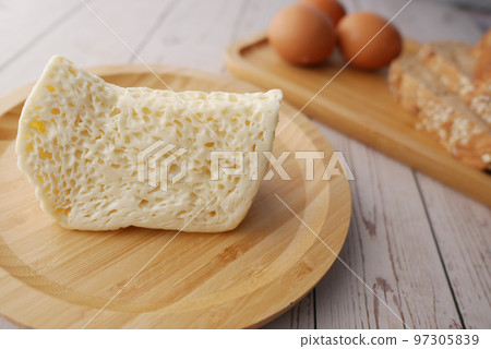 Close up of cheese, milk , brown bread and almond nut on table. Close up of cheese, milk , brown bread and almond nut on table. 97305839