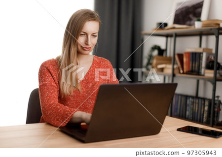 Woman using laptop at home Woman using laptop at home 97305943