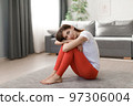 Woman sitting on floor after workout 97306004