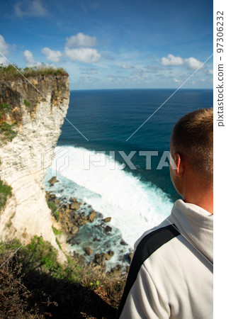 a man stands on a cliff a man stands on a cliff 97306232