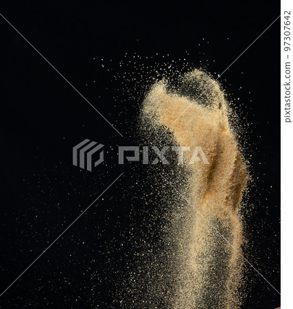 Sand flying explosion, Golden sand wave explode. Abstract sands cloud fly. Yellow colored sand splash throwing in Air. black background Isolated high speed shutter, throwing freeze stop motion 97307642