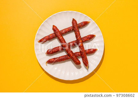 Flat lay of Spanish mini chorizo on yellow 97308602