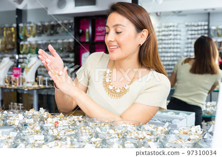 Young adult woman choosing bijouterie in store 97310034
