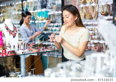Latin american female shopper looking for bracelet in jewelry shop Latin american female shopper looking for bracelet in jewelry shop 97310035