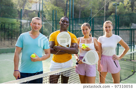Group photo of positive people on padel tennis court 97310058