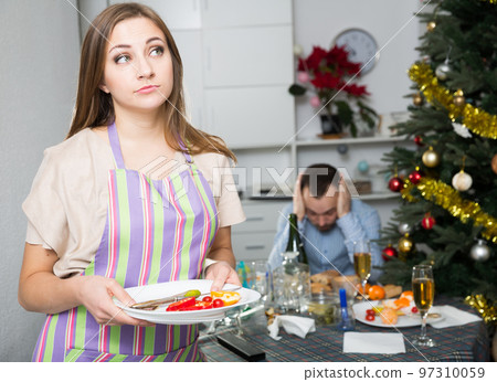 Offended woman clearing table Offended woman clearing table 97310059