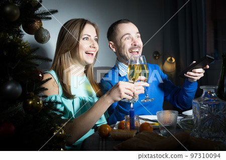 Man and woman watching tv at Christmas night 97310094