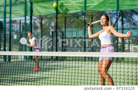 Two women tennis players playing padel Two women tennis players playing padel 97310120
