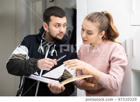 Woman discussing apartment lease agreement with landlord 97310329