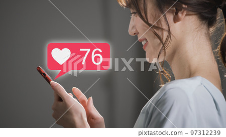 Young woman operating a smartphone at night Young woman operating a smartphone at night 97312239